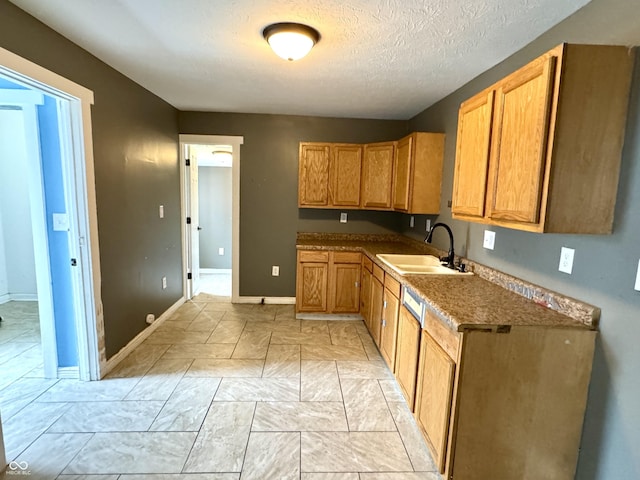 104 W Pearl St, Trafalgar, IN 46181 - kitchen featuring a sink, baseboards, a textured ceiling, brown cabinetry, and light marble finish flooring