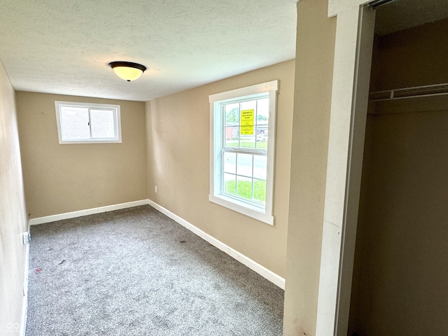 104 W Pearl St, Trafalgar, IN 46181 - unfurnished bedroom with multiple windows, carpet floors, baseboards, and a textured ceiling