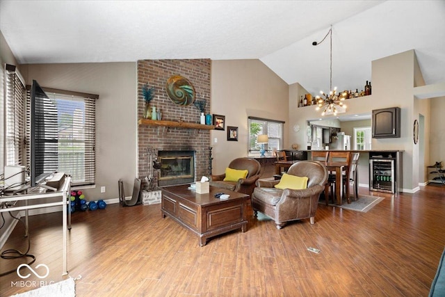 11041 Limbach Cir, Indianapolis, IN 46236 - living area featuring beverage cooler, light wood finished floors, a brick fireplace, a chandelier, and high vaulted ceiling
