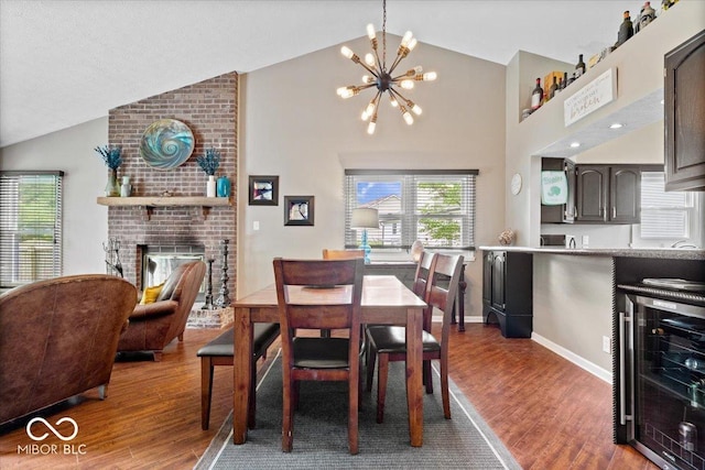 11041 Limbach Cir, Indianapolis, IN 46236 - dining space with wine cooler, wood finished floors, a chandelier, a fireplace, and high vaulted ceiling
