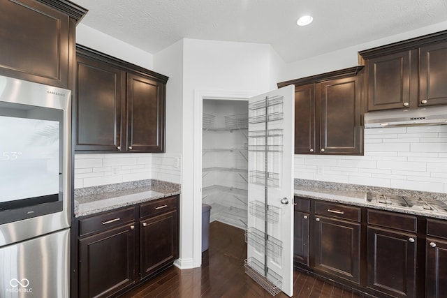 15292 Slateford Rd, Noblesville, IN 46062 - kitchen featuring smart refrigerator, under cabinet range hood, light stone counters, dark wood-style floors, and stainless steel gas stovetop