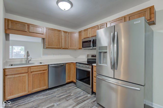 8684 Captain Dr, Avon, IN 46123 - kitchen with stainless steel appliances, a sink, light countertops, and light wood-type flooring