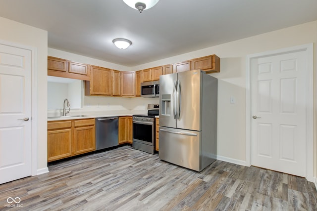 8684 Captain Dr, Avon, IN 46123 - kitchen featuring appliances with stainless steel finishes, a sink, light countertops, and light wood finished floors
