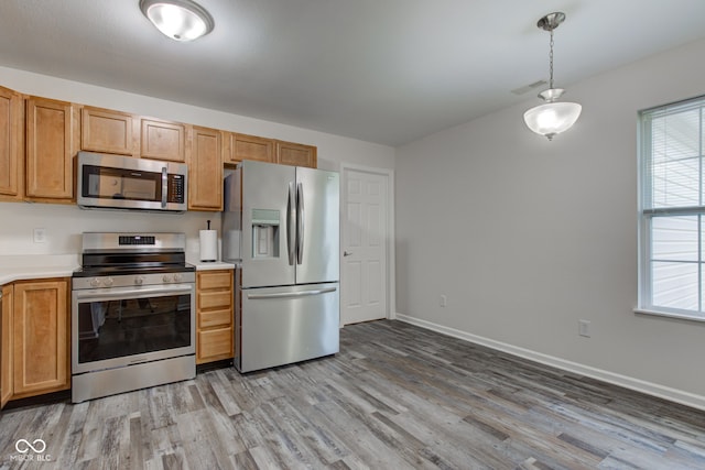 8684 Captain Dr, Avon, IN 46123 - kitchen featuring appliances with stainless steel finishes, light wood finished floors, light countertops, baseboards, and decorative light fixtures