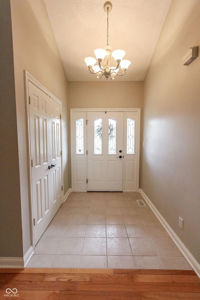 7093 Republic Ln, Indianapolis, IN 46259 - entryway with a chandelier, baseboards, light tile patterned floors, and vaulted ceiling