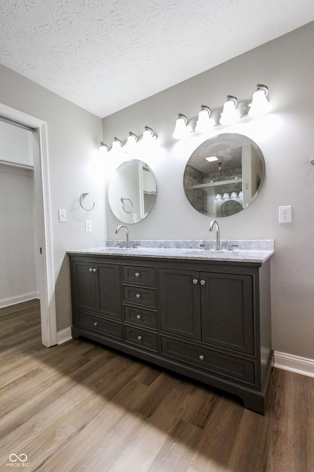 7093 Republic Ln, Indianapolis, IN 46259 - bathroom with wood finished floors, baseboards, double vanity, and a textured ceiling