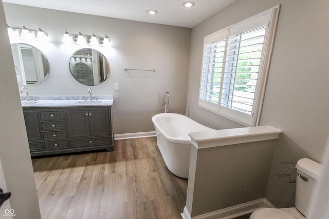 7093 Republic Ln, Indianapolis, IN 46259 - bathroom with wood finished floors, a soaking tub, toilet, baseboards, and double vanity