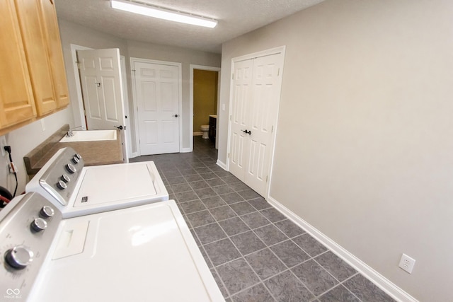 7093 Republic Ln, Indianapolis, IN 46259 - laundry area with washer and dryer, cabinet space, dark tile patterned floors, baseboards, and a textured ceiling