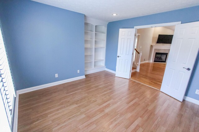 7093 Republic Ln, Indianapolis, IN 46259 - spare room with baseboards, light wood-style floors, built in features, a fireplace, and recessed lighting