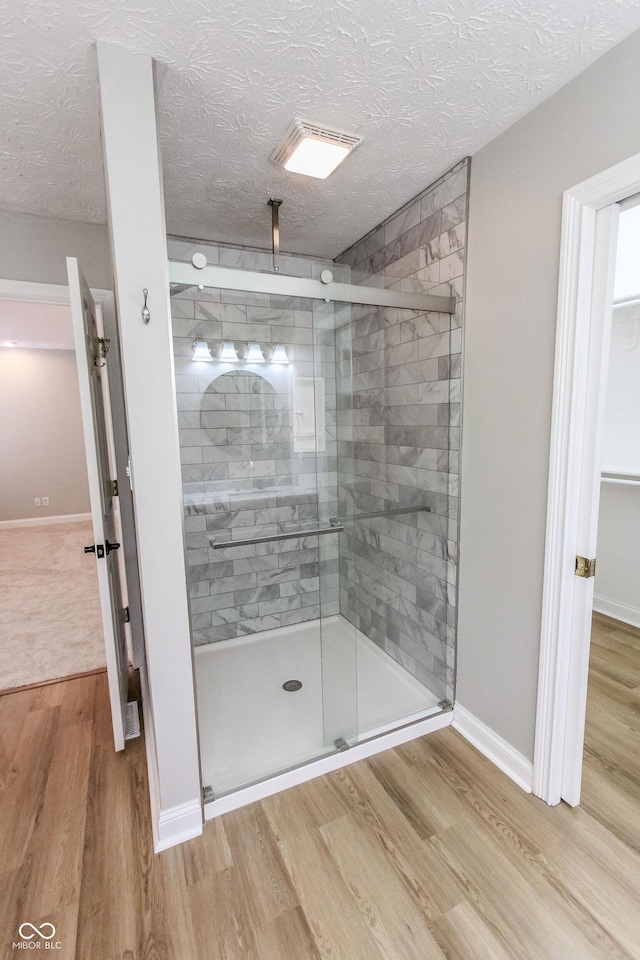 7093 Republic Ln, Indianapolis, IN 46259 - full bath featuring wood finished floors, a shower stall, a textured ceiling, and baseboards