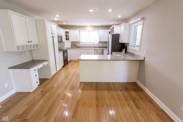 7093 Republic Ln, Indianapolis, IN 46259 - kitchen with appliances with stainless steel finishes, a peninsula, a sink, light wood finished floors, and white cabinets
