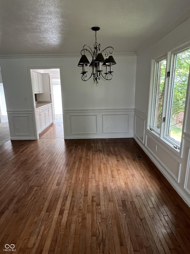 213 Golf Ct, Greenwood, IN 46143 - unfurnished dining area with a decorative wall, dark wood-style floors, a chandelier, ornamental molding, and wainscoting