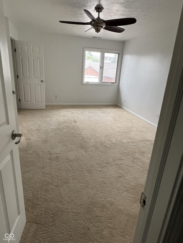 213 Golf Ct, Greenwood, IN 46143 - spare room featuring ceiling fan, light carpet, and a textured ceiling