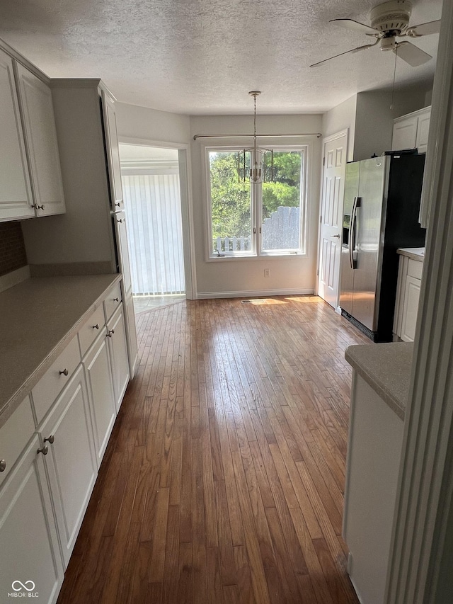 213 Golf Ct, Greenwood, IN 46143 - kitchen featuring stainless steel fridge, dark wood-type flooring, white cabinets, a ceiling fan, and a textured ceiling