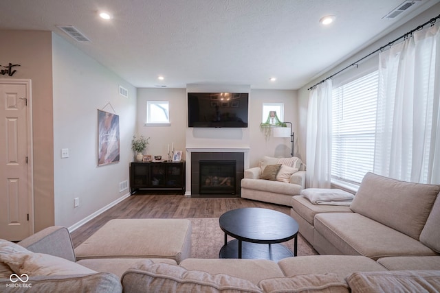 19144 Goins Blvd, Westfield, IN 46074 - living room with wood finished floors, baseboards, recessed lighting, a tile fireplace, and a textured ceiling