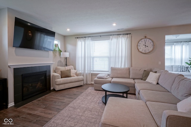 19144 Goins Blvd, Westfield, IN 46074 - living room with dark wood finished floors, healthy amount of natural light, a tiled fireplace, and recessed lighting