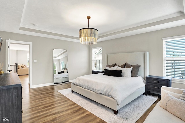 4602 Hayward Way, Westfield, IN 46062 - bedroom featuring a tray ceiling, wood finished floors, arched walkways, and baseboards