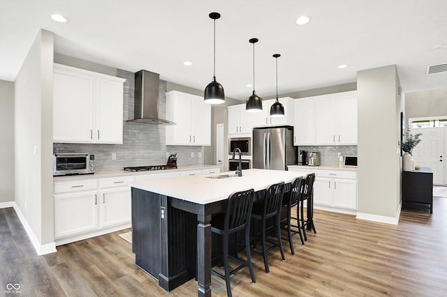 4602 Hayward Way, Westfield, IN 46062 - kitchen featuring wall chimney exhaust hood, appliances with stainless steel finishes, a sink, light wood-type flooring, and recessed lighting