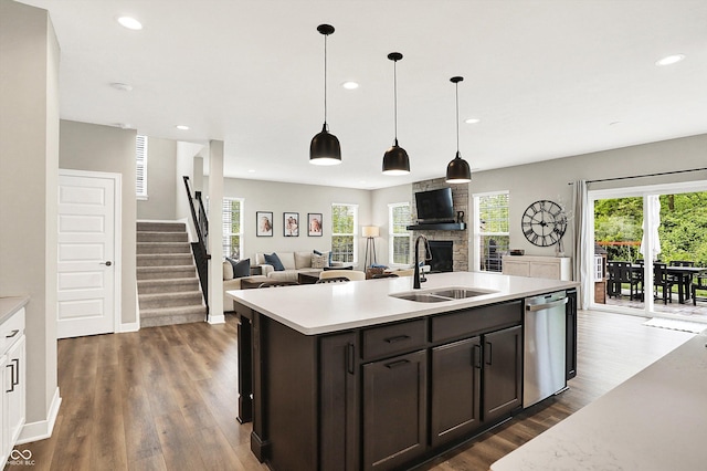 4602 Hayward Way, Westfield, IN 46062 - kitchen featuring a sink, dishwasher, open floor plan, a stone fireplace, and light countertops