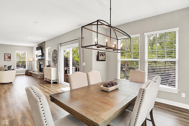 4602 Hayward Way, Westfield, IN 46062 - dining area featuring wood finished floors, a chandelier, baseboards, recessed lighting, and a stone fireplace