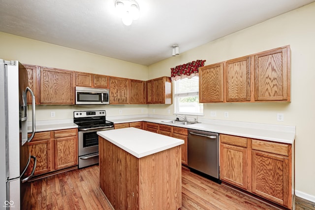 1306 Flat Wood Ct, Brownsburg, IN 46112 - kitchen with stainless steel appliances, light wood-style floors, a center island, and light countertops