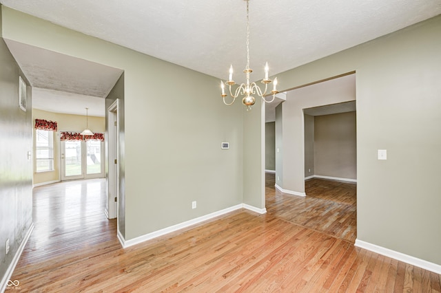1306 Flat Wood Ct, Brownsburg, IN 46112 - spare room featuring light wood-style flooring and a chandelier