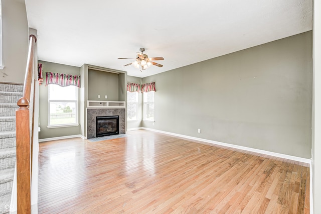1306 Flat Wood Ct, Brownsburg, IN 46112 - unfurnished living room with light wood-style floors, a ceiling fan, and a tile fireplace