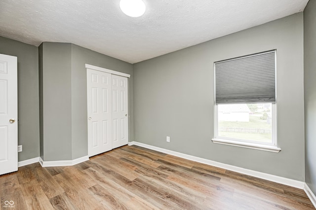 1306 Flat Wood Ct, Brownsburg, IN 46112 - unfurnished bedroom featuring wood finished floors, a closet, and a textured ceiling