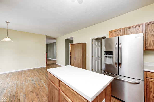 1306 Flat Wood Ct, Brownsburg, IN 46112 - kitchen with stainless steel refrigerator with ice dispenser, light wood-type flooring, light countertops, a center island, and hanging light fixtures