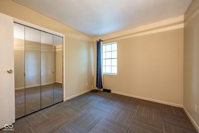 6 Heritage Dr, Terre Haute, IN 47803 - unfurnished bedroom with baseboards, a closet, and dark colored carpet