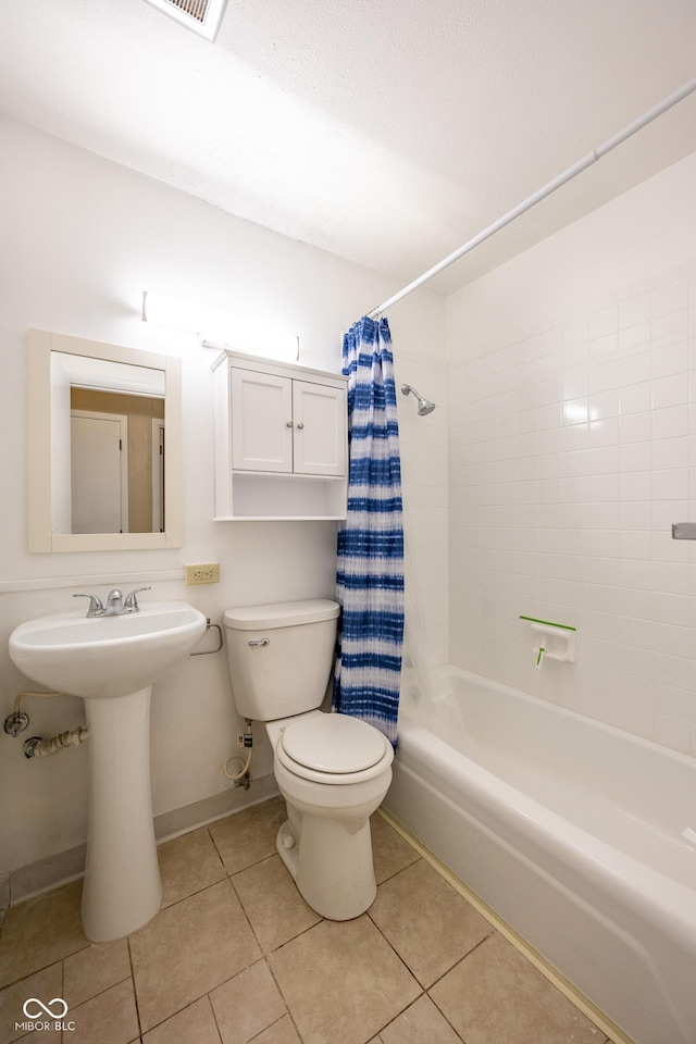 6 Heritage Dr, Terre Haute, IN 47803 - bathroom with toilet, shower / bath combo with shower curtain, tile patterned floors, a sink, and baseboards