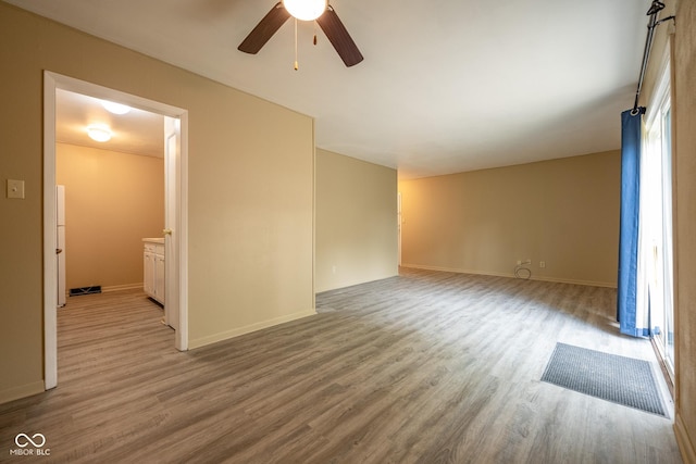 6 Heritage Dr, Terre Haute, IN 47803 - empty room with wood finished floors, a ceiling fan, and baseboards