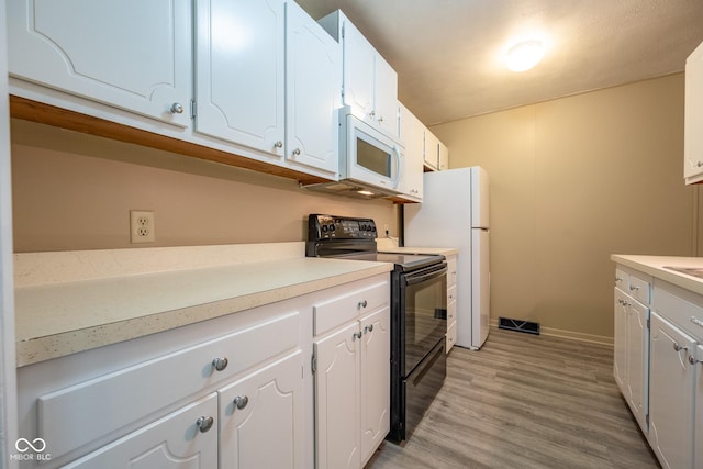 6 Heritage Dr, Terre Haute, IN 47803 - kitchen with white appliances, white cabinetry, light wood-style flooring, baseboards, and light countertops