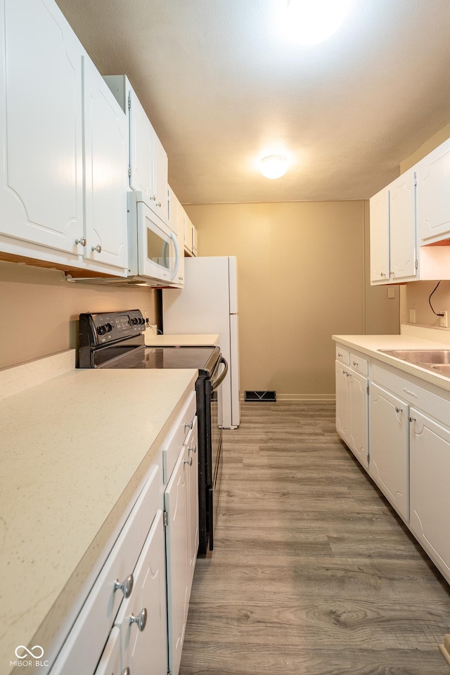 6 Heritage Dr, Terre Haute, IN 47803 - kitchen featuring white microwave, black range with electric cooktop, white cabinets, and a sink