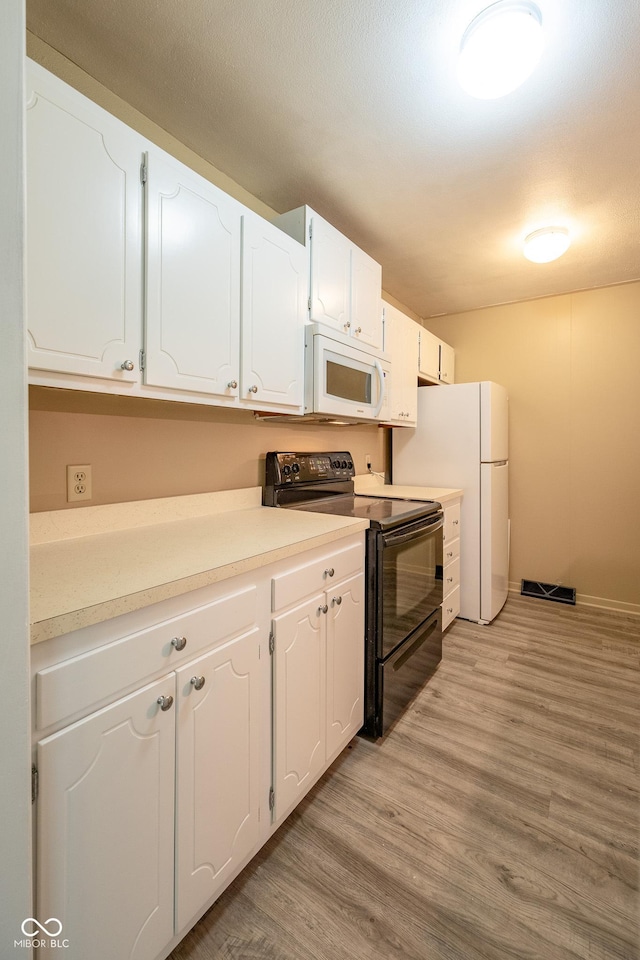 6 Heritage Dr, Terre Haute, IN 47803 - kitchen featuring white appliances, white cabinetry, light wood-type flooring, and light countertops