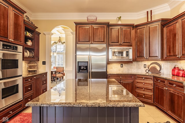 4930 Benthaven Dr E, Bargersville, IN 46106 - kitchen with appliances with stainless steel finishes, ornate columns, crown molding, a kitchen island, and tasteful backsplash