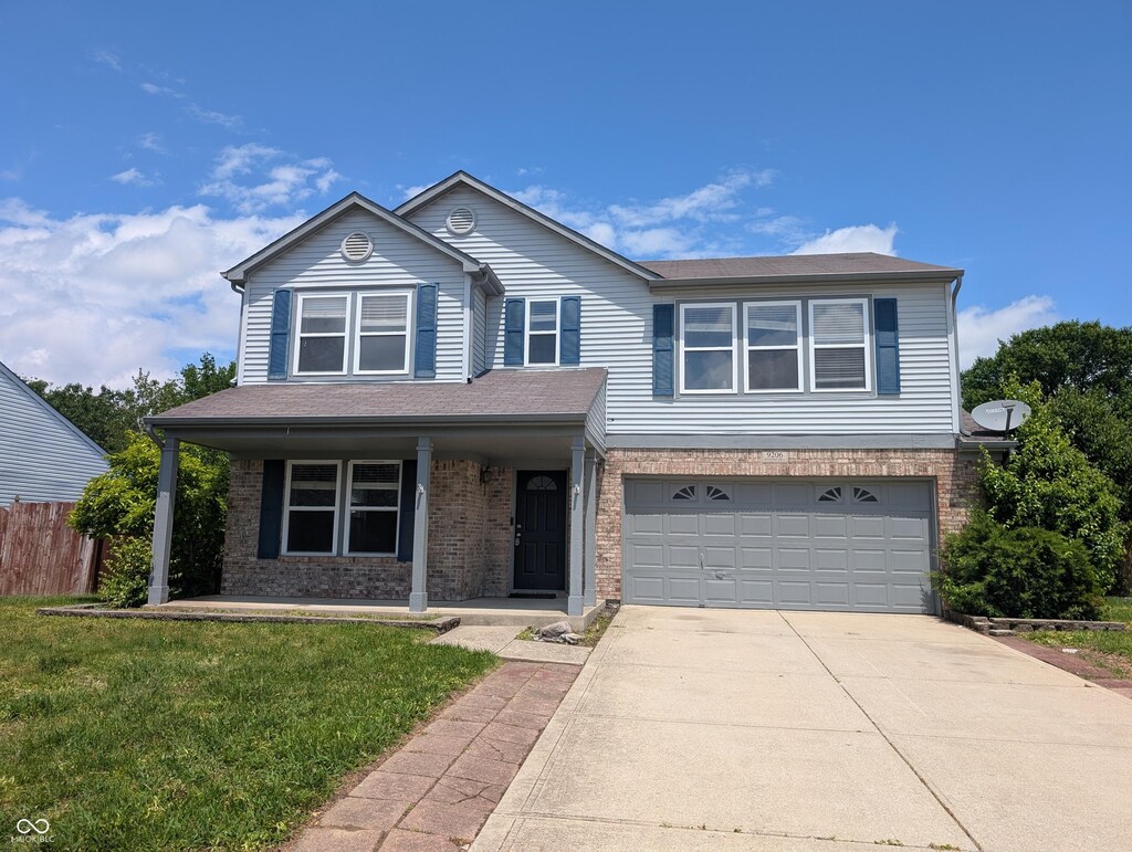 9206 Huntleigh Cir, Plainfield, IN 46168 - view of front of house with an attached garage, concrete driveway, brick siding, a porch, and roof with shingles