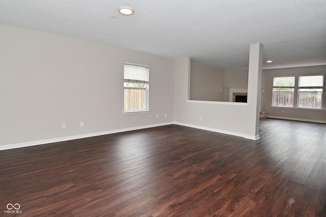 9206 Huntleigh Cir, Plainfield, IN 46168 - unfurnished living room featuring dark wood-type flooring, a textured ceiling, a fireplace, and recessed lighting