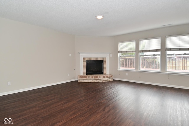 9206 Huntleigh Cir, Plainfield, IN 46168 - unfurnished living room featuring dark wood finished floors, a brick fireplace, and a textured ceiling