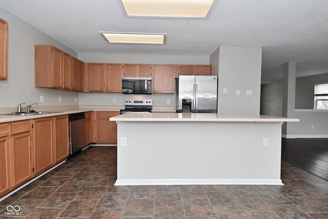 9206 Huntleigh Cir, Plainfield, IN 46168 - kitchen with appliances with stainless steel finishes, a kitchen island, light countertops, and a textured ceiling
