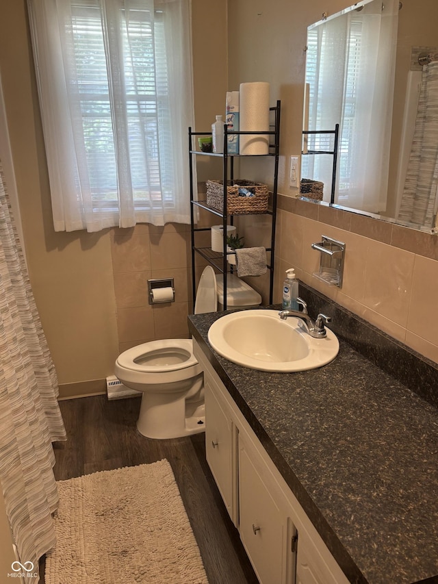 3031 W 18th St, Indianapolis, IN 46222 - bathroom with wood finished floors, toilet, tile walls, vanity, and tasteful backsplash