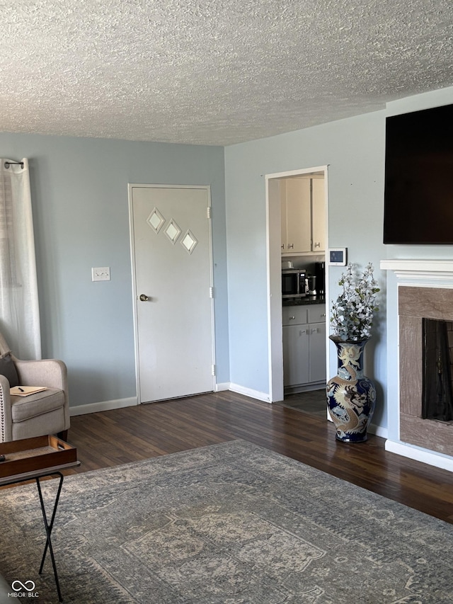 3031 W 18th St, Indianapolis, IN 46222 - living room featuring dark wood-style flooring, baseboards, a fireplace, and a textured ceiling