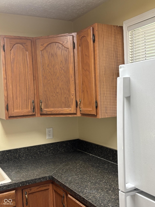 3031 W 18th St, Indianapolis, IN 46222 - kitchen with freestanding refrigerator, dark countertops, and brown cabinets