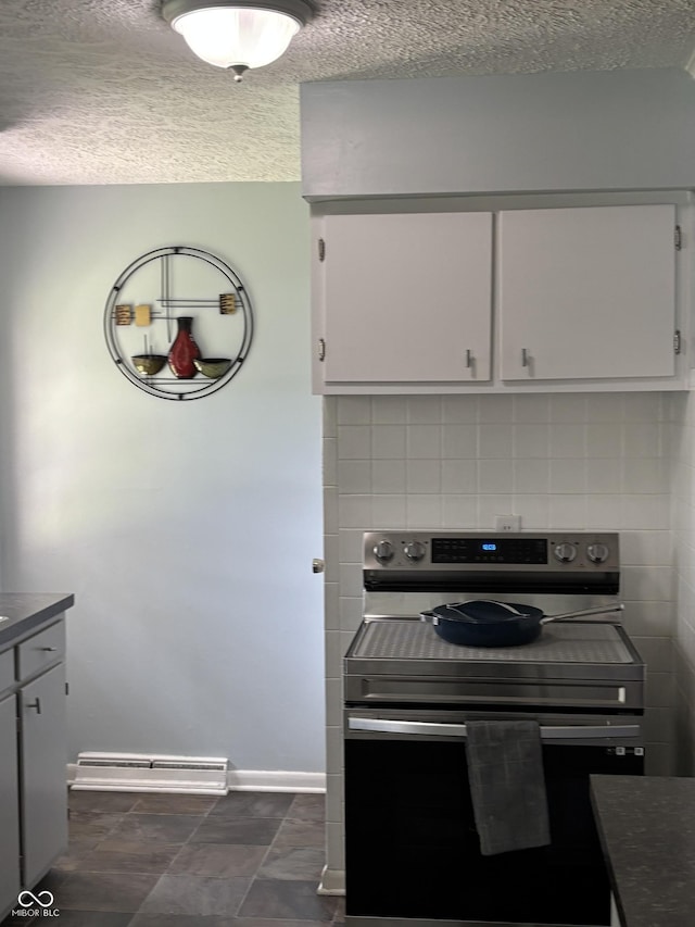 3031 W 18th St, Indianapolis, IN 46222 - kitchen with stainless steel electric stove, a textured ceiling, dark countertops, baseboards, and baseboard heating