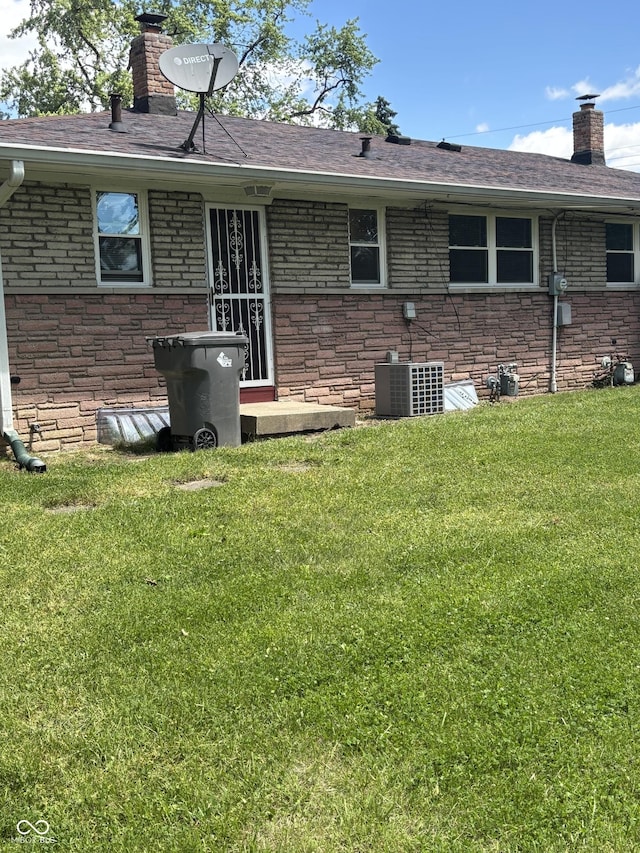 3031 W 18th St, Indianapolis, IN 46222 - back of property featuring a chimney, a yard, brick siding, and cooling unit