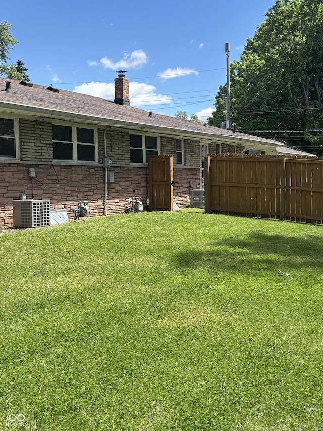 3031 W 18th St, Indianapolis, IN 46222 - back of property featuring a chimney, central air condition unit, and roof with shingles