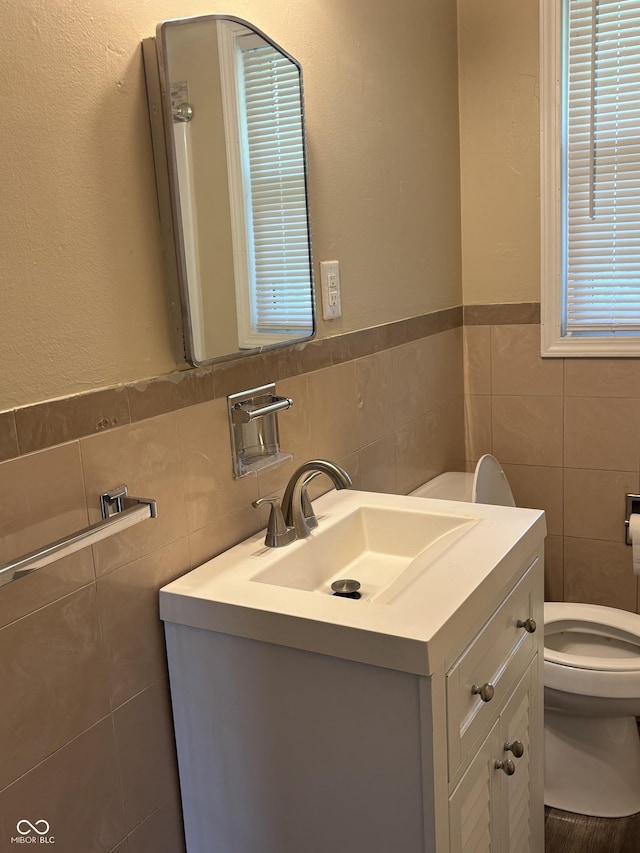 3031 W 18th St, Indianapolis, IN 46222 - bathroom featuring tile walls, toilet, vanity, and wainscoting