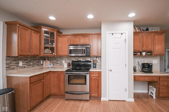 60 Bittersweet Ct, Seymour, IN 47274 - kitchen with appliances with stainless steel finishes, light countertops, light wood-type flooring, brown cabinetry, and recessed lighting