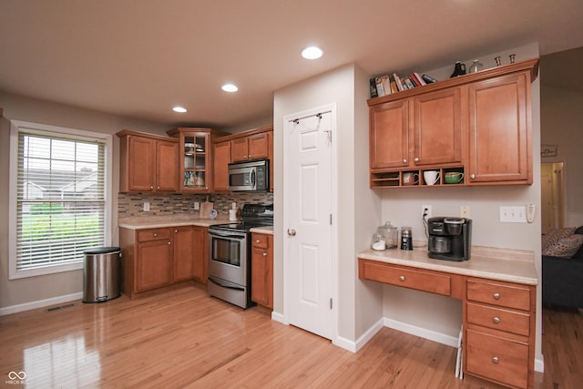60 Bittersweet Ct, Seymour, IN 47274 - kitchen with stainless steel appliances, light wood-style flooring, brown cabinets, baseboards, and light countertops
