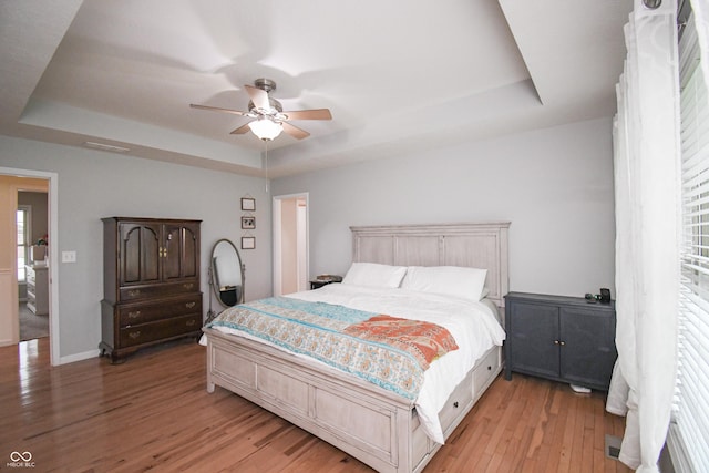 60 Bittersweet Ct, Seymour, IN 47274 - bedroom with a tray ceiling, light wood-style flooring, multiple windows, and baseboards